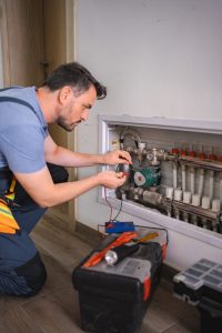 Technician checking domestic heating system with multimeter Technician checking domestic heating system with multimeter